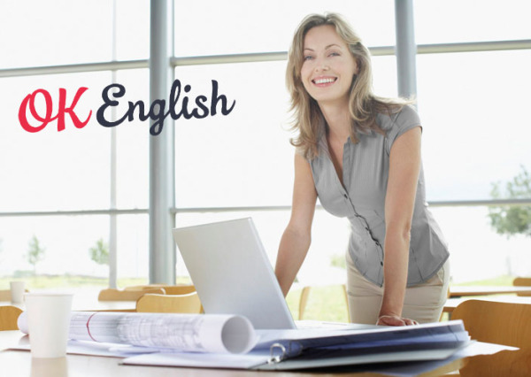 Businesswoman at desk with blueprints and laptop